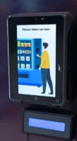 Unattended touchscreen payment terminal showing a “Please Select an Item” vending-style screen