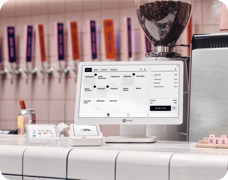 SumUp POS Lite and Solo card reader on a café counter with a touchscreen menu and coffee shop background